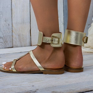 Side profile of the gold leather ankle cuff sandal style, showing the low 1.2cm heel height.