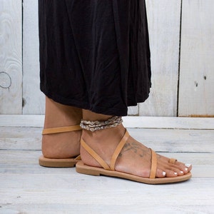 Side view of the sandal. Shows the thin, flexible rubber outsole and the open-back, easy slip-on style.