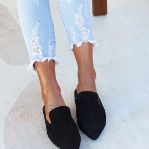 Close-up of black suede texture and stitching — Loraine mules