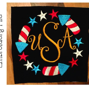 Puede incluir: Parche bordado negro con un diseño patriótico. Presenta la palabra "USA" en letras doradas, rodeada de fuegos artificiales y estrellas rojas, blancas y azules. Un diseño festivo para el Día de la Independencia.