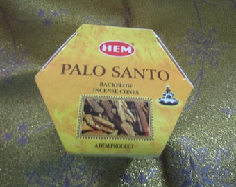 May include: A yellow hexagonal box with the text "HEM" in red and "PALO SANTO" in black. The box also includes the text "Backflow Incense Cones" and "A HEM Product".