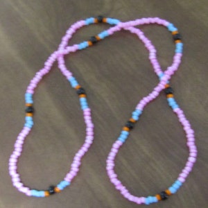 May include: A pink and blue beaded necklace with black beads interspersed throughout.