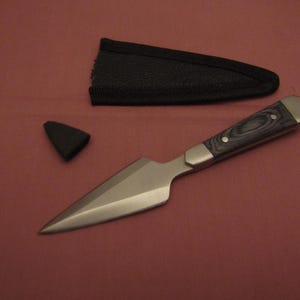 May include: A silver throwing knife with a black and blue wooden handle and a black sheath.