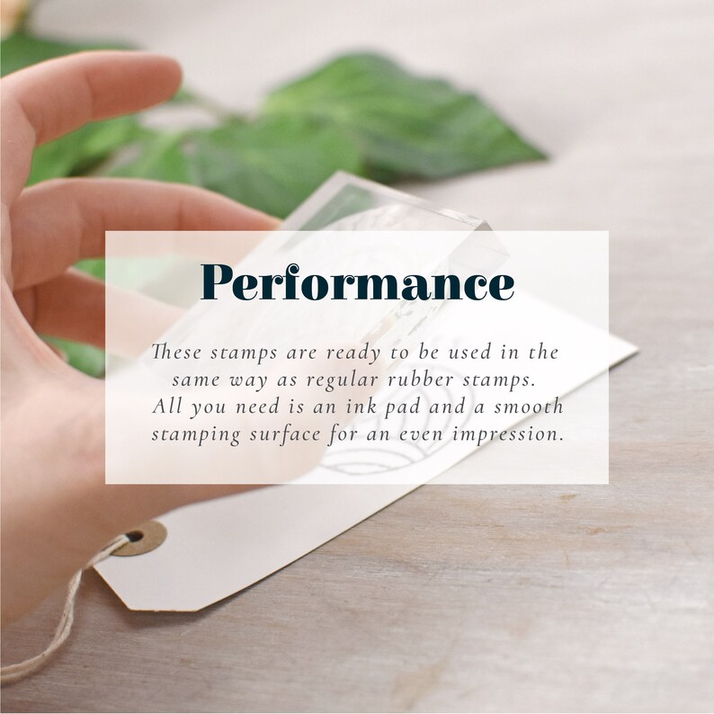 May include: A clear, rectangular stamp held over a white tag. The text "Performance" is displayed in a bold, dark font. The tag is attached to a string. The background is a light wooden surface.