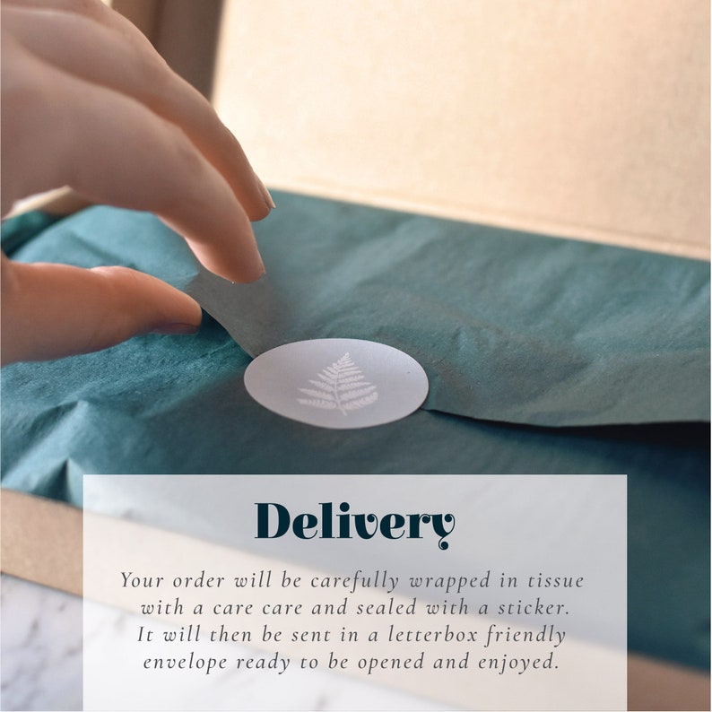 May include: A package wrapped in teal tissue paper, sealed with a white oval sticker featuring a fern design. The word "Delivery" is displayed in a decorative font. The package is inside a cardboard box.