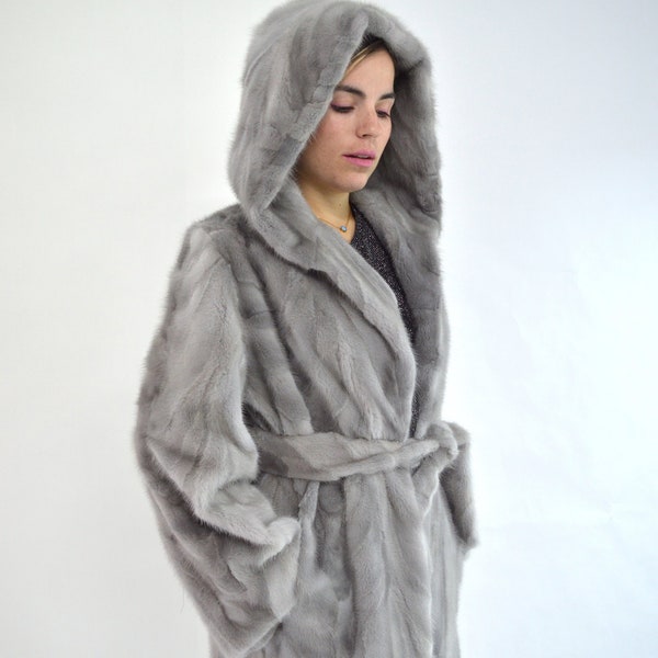 Real sapphire mink fur coat with hood and belt. Genuine mink stroller in gray, unique jacket from premium mink skins, farming fur pelts.