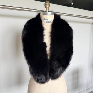 May include: A luxurious black fur collar displayed on a vintage dress form. The collar is thick and plush, with a deep, rich black color. The dress form is a neutral beige, with the text "ROYAL FORM" visible.