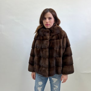 K&ouml;nnte beinhalten: Eine braune Pelzjacke mit Stehkragen und Knopfleiste.