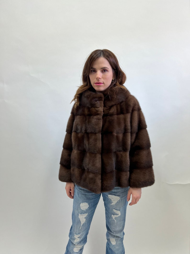 K&ouml;nnte beinhalten: Eine braune Pelzjacke mit Stehkragen und Knopfleiste.