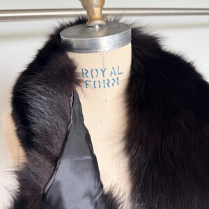 May include: A luxurious black fur collar with a satin lining. The collar is displayed on a mannequin with the words "ROYAL FORM" printed on it. The fur appears soft and plush, with a deep, rich color.