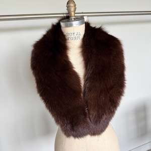 May include: A luxurious brown fur collar displayed on a vintage dress form. The collar is a rich, dark brown color and appears soft and plush. The dress form has the text "ROYAL FORM" and "COLLAPSIBLE MODEL 2000".