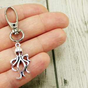 May include: Silver octopus keychain with a silver lobster clasp.