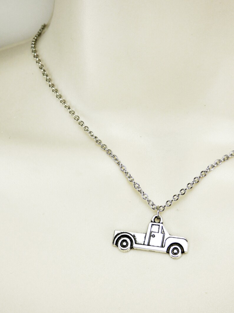 Op de afbeelding: Een zilveren ketting met een zilveren pick-up truck bedel.