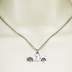 Op de afbeelding: Een zilveren ketting met een zilveren aanhanger in de vorm van een pick-up truck.