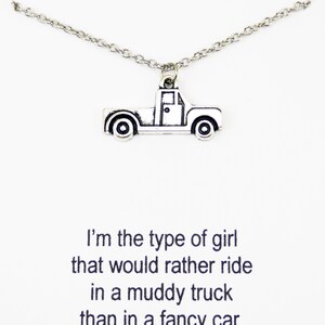 Op de afbeelding: Zilveren ketting met een truckbedel. De ketting heeft een citaat dat luidt: "Ik ben het type meisje dat liever in een modderige truck rijdt dan in een chique auto."