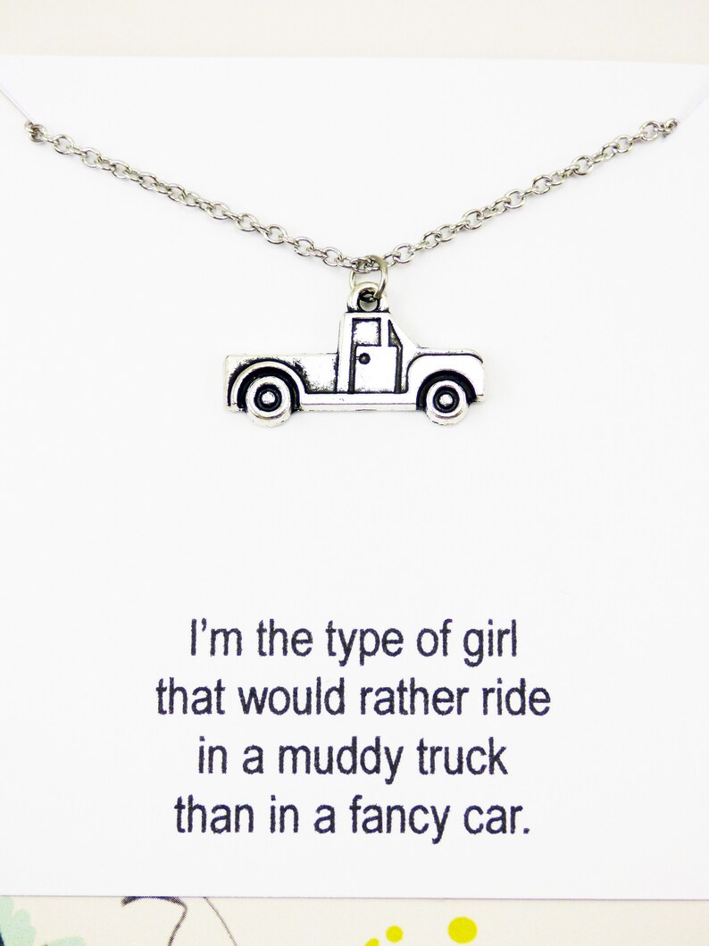 Op de afbeelding: Zilveren ketting met een truckbedel. De ketting heeft een citaat dat luidt: "Ik ben het type meisje dat liever in een modderige truck rijdt dan in een chique auto."