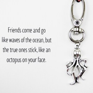 May include: A silver octopus keychain with a quote that reads "Friends come and go like waves of the ocean, but the true ones stick, like an octopus on your face."