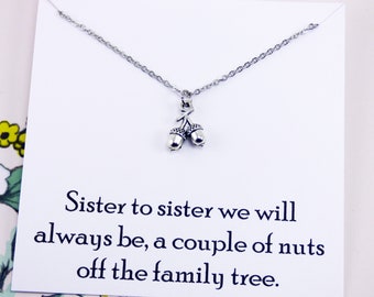 May include: A silver necklace with a charm of two acorns. The card attached to the necklace reads "Sister to sister we will always be, a couple of nuts off the family tree."