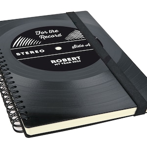 Könnte beinhalten: Schwarzes Spiralblock mit Vinylplatten-Design. Der Umschlag zeigt den Text "For the Record", "Stereo", "Side A" und "Robert My Year 2024".