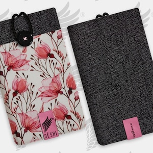 Könnte beinhalten: Zwei Handyhüllen. Eine Hülle hat ein Blumenmuster mit rosa Blüten und grünen Stielen auf weißem Grund. Die andere Hülle ist einfarbig schwarz. Beide Hüllen haben einen schwarzen Denim-Oberteil und ein rosa Etikett mit Text.