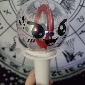 Lee Know / Leebit is placed on the round side of the lightstick using black removable vinyl.