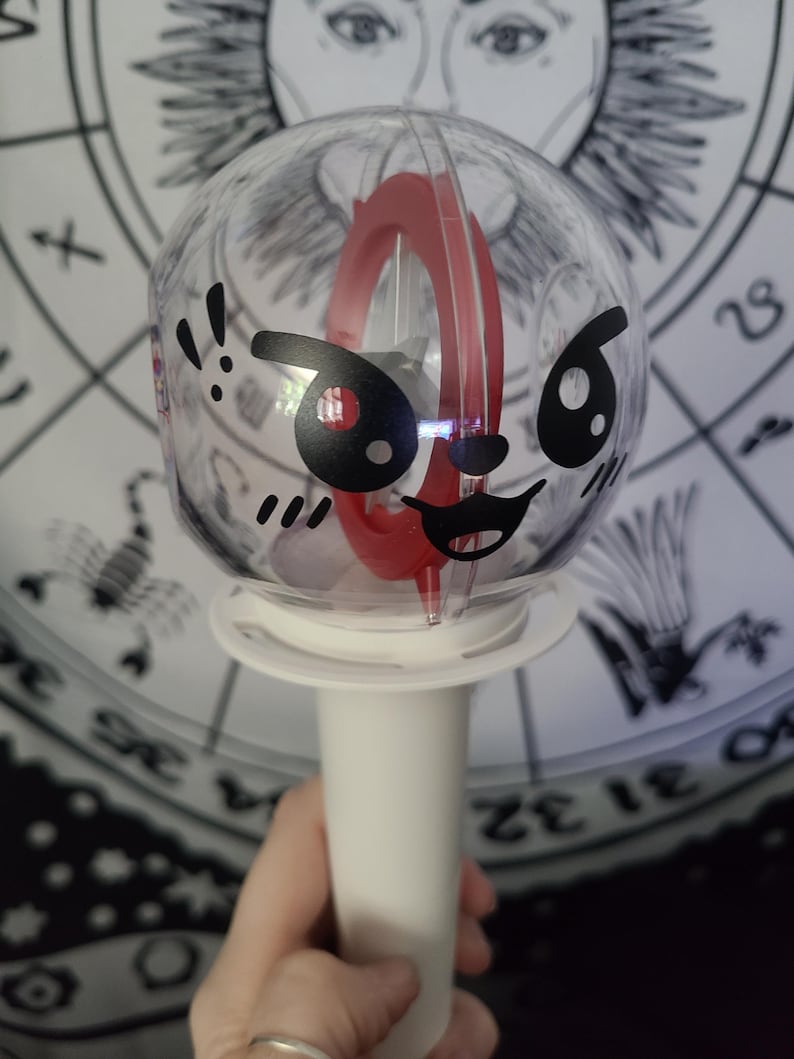 Lee Know / Leebit is placed on the round side of the lightstick using black removable vinyl.