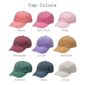 May include: Nine baseball caps in various colors, including coral, hot pink, pink, burgundy, lilac, mustard, forrest green, navy, and ivory. The text "Cap Colors" is at the top of the image.