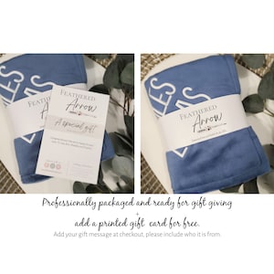 Peut inclure: Une couverture bleue et blanche avec le mot "bless" brod&eacute; dessus. La couverture est pli&eacute;e et emball&eacute;e avec une carte blanche qui dit "Feathered Arrow" et "A special gift".