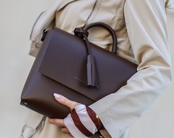 Bolso minimalista de piel marrón oscuro hecho a mano con borla