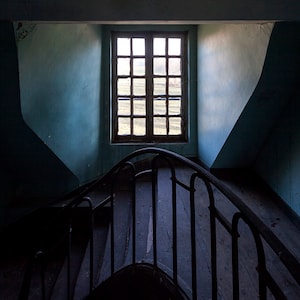 Chiaroscuro photography of a staircase in an abandoned chateau in France