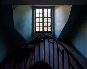 Chiaroscuro photography of a staircase in an abandoned chateau in France