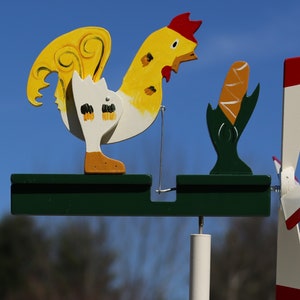 May include: A wooden weather vane featuring a yellow and white rooster with a red comb, a green corn stalk with a yellow ear of corn, and a white and red propeller.