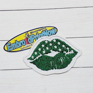 May include: Green lips with white stars embroidered on a white background. The patch is for sewing or ironing onto fabric. The patch is from Embroider & Print Now in Minneapolis.