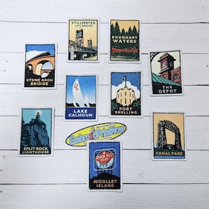 May include: Ten colorful embroidered patches featuring landmarks and businesses in Minneapolis, Minnesota. The patches are rectangular and have white borders. The patches include the Stone Arch Bridge, the Stillwater Lift Bridge, Boundary Waters, Lake Calhoun, Fort Snelling, The Depot, Split Rock Lighthouse, Canal Park, Grain Belt Beer, and Nicollet Island.