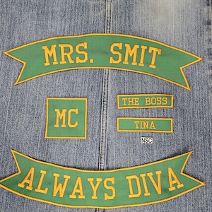 May include: A collection of green and gold embroidered patches on a denim background. The patches include the text "MRS. SMIT", "MC", "THE BOSS", "TINA", and "ALWAYS DIVA".