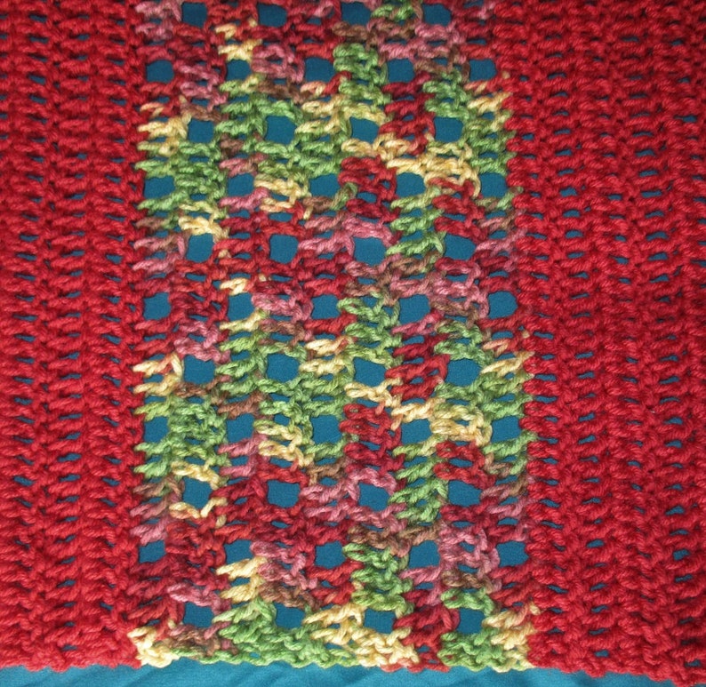 Puede incluir: Bufanda de ganchillo hecha a mano con una paleta de colores vibrantes. La bufanda tiene un borde rojo s&oacute;lido a cada lado, con una secci&oacute;n central que muestra una mezcla de tonos verdes, amarillos, rosas y rojos. El dise&ntilde;o de tejido abierto a&ntilde;ade una textura &uacute;nica.
