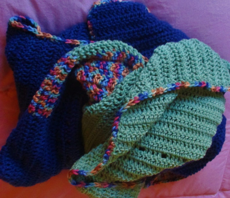 May include: A blue, green, and multi-colored crocheted blanket with a textured pattern.