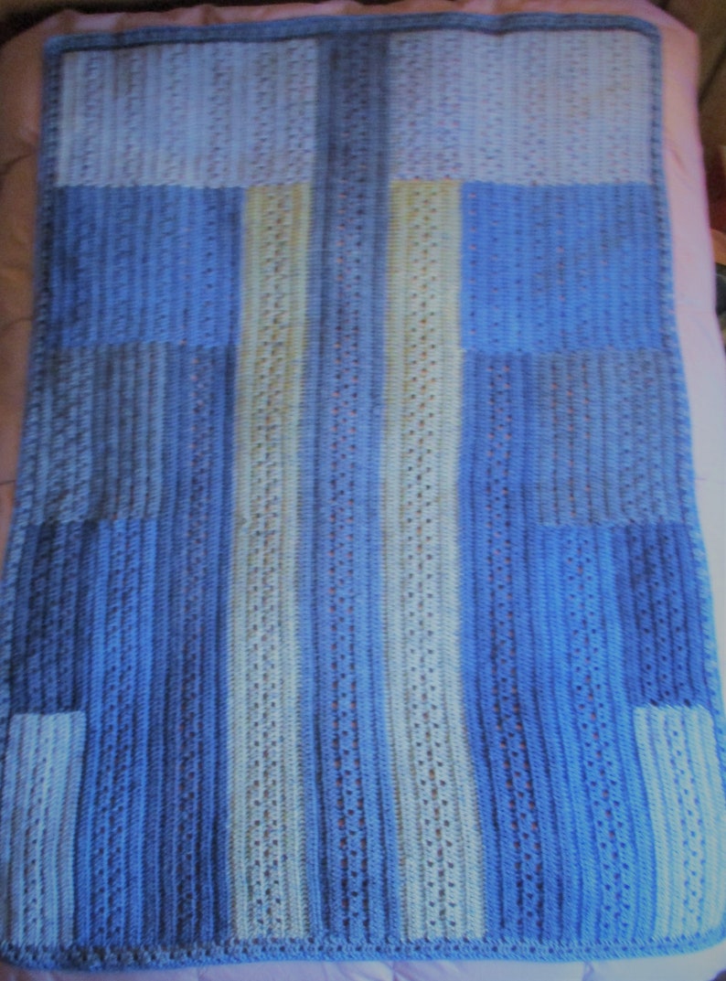 May include: A blue and white crocheted baby blanket with a geometric pattern.
