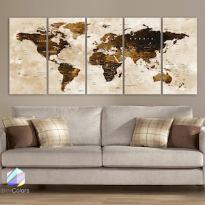 May include: A vintage-style world map print in brown tones, divided into five panels, with the continents and oceans clearly labeled. The map is displayed on a wall above a light gray couch with brown and beige throw pillows.