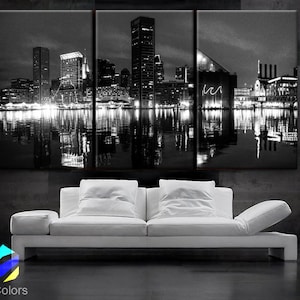 May include: A black and white photograph of a city skyline at night. The city is reflected in the water below. The buildings are tall and slender, and the lights of the city are visible in the water.