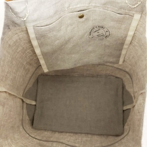 Puede incluir: Una bolsa de lona beige con un bolsillo interior grande y una peque&ntilde;a etiqueta redonda marr&oacute;n que dice "Vintage & Made" en letras blancas. La bolsa est&aacute; vac&iacute;a y el interior es visible.