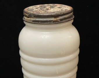 This is a Fire King pepper shaker with a metal lid. 4.1/2" tall  and is made of milk glass. 1950s  very good vintage condition.