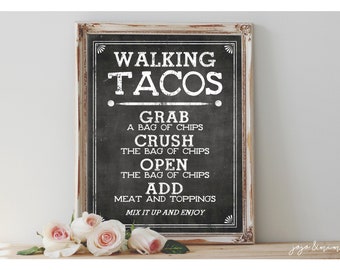 May include: A framed chalkboard sign with the text "WALKING TACOS" and instructions for making them. The sign is black with white lettering and a distressed white frame. Pink roses are at the bottom.