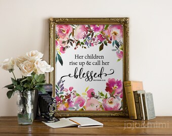 Pode incluir: Uma impressão emoldurada com um design floral em aquarela e a citação "Seus filhos se levantam e a chamam de abençoada" com a referência bíblica "Provérbios 31:28".