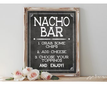 May include: A black chalkboard sign with white text that reads "NACHO BAR" and instructions for making nachos: "1. Grab some chips", "2. Add cheese", "3. Choose your toppings", and "And enjoy!"