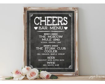 May include: A chalkboard sign with a white frame, listing a bar menu for a wedding reception. The sign reads "CHEERS BAR MENU" and lists the bride's choice, groom's choice, beer, and wine options.