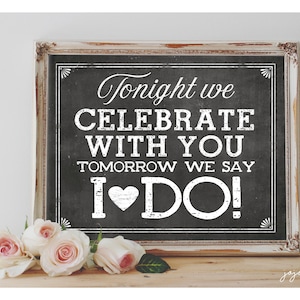 May include: A white framed chalkboard sign with the text "Tonight we celebrate with you. Tomorrow we say I ♥ DO!" in white lettering on a black background.