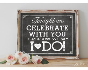 May include: A white framed chalkboard sign with the text "Tonight we celebrate with you. Tomorrow we say I ♥ DO!" in white lettering on a black background.