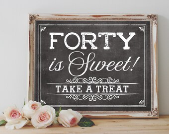 以下が含まれることがあります： ヴィンテージ風のフォントで「FORTY is Sweet! TAKE A TREAT」と書かれた黒いチョークボードのサイン。白い、使い古した木製のフレームで囲まれています。