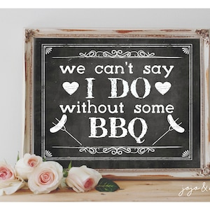May include: A white sign with black text on a chalkboard background. The sign reads "We can't say I DO without some BBQ."  The sign is framed in a rustic white frame.